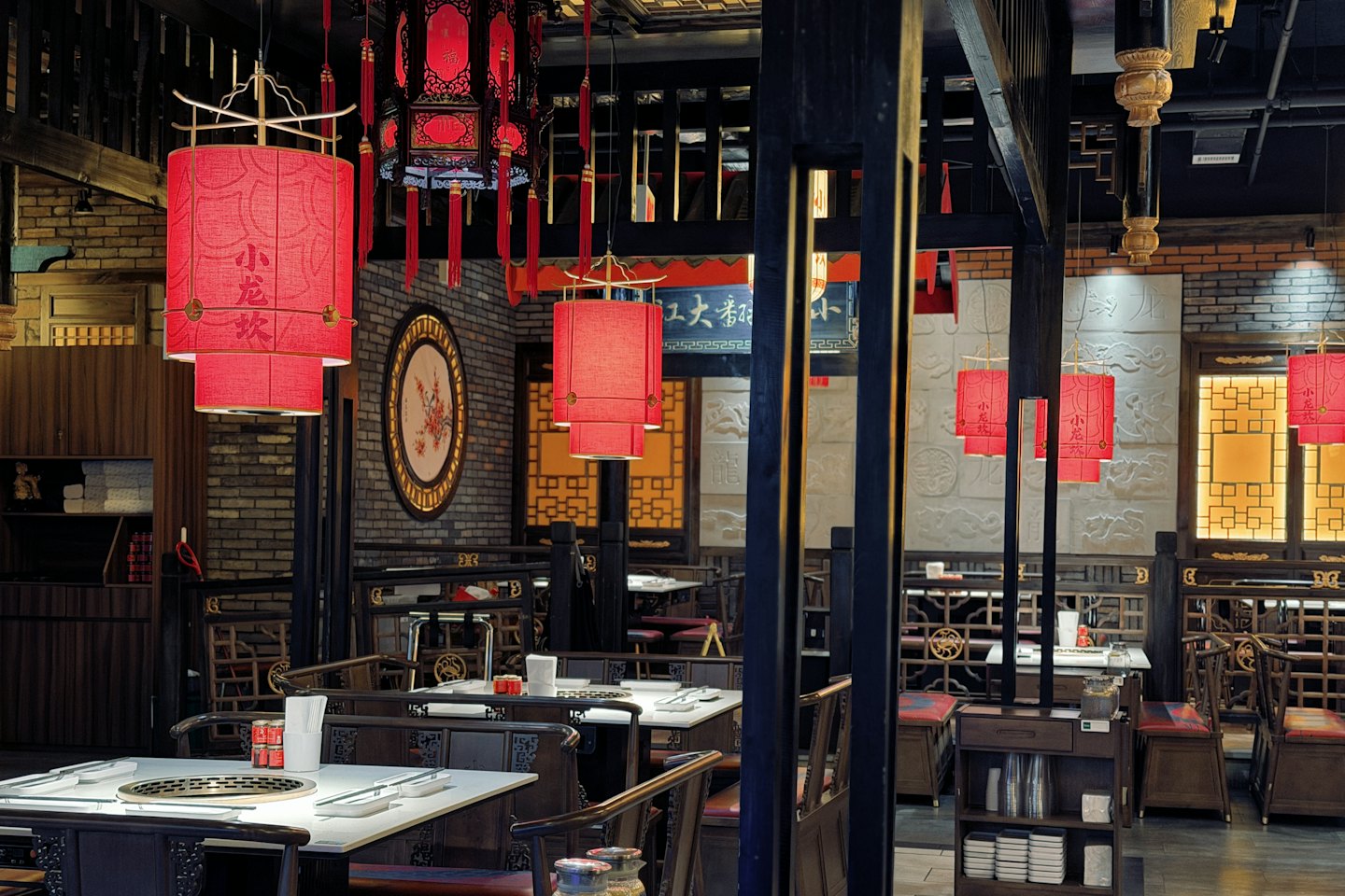 Red lanterns hang above tables inside a traditional restaurant.
